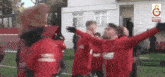 a group of soccer players are celebrating with their arms outstretched in front of a building that says ganli on it