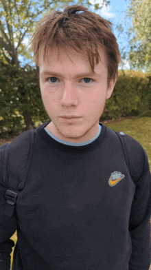 a man wearing a black nike shirt with a yellow nike logo