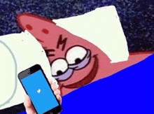 patrick star from spongebob squarepants is holding a cell phone with a twitter logo on it .