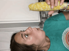 a woman in a ll bean shirt is holding a corn on the cob