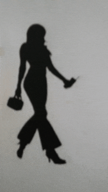 a silhouette of a woman holding a purse and a cell phone