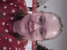 a woman wearing glasses and a red sweater with white stars on it