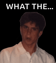 a man in a white shirt is standing in front of a black background that says " what the "