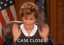 a judge is sitting in a courtroom with her hands in the air and the words `` case closed '' .