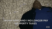 a man laying on a pile of money with the words trump wins and i no longer pay property taxes above him