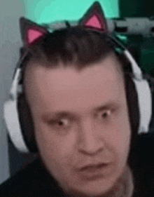 a man is wearing headphones and a cat ear headband .