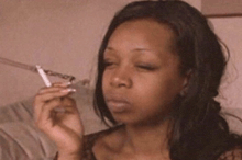a woman is smoking a cigarette with a chain around her finger