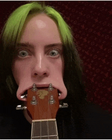 a woman with green hair is holding a guitar with her mouth wide open