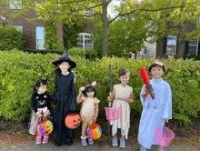 a group of children dressed in halloween costumes are standing on the sidewalk