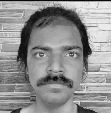 a black and white photo of a man with a moustache