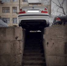 a bmw car is parked in a narrow space between two concrete blocks