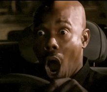 a man with a surprised look on his face is sitting in a car