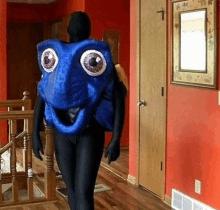 a man in a blue fish costume is walking through a hallway .