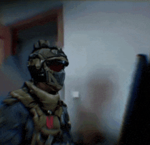 a soldier wearing a helmet and mask is looking at a computer monitor