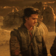 a man with a shield on his back is standing in a desert