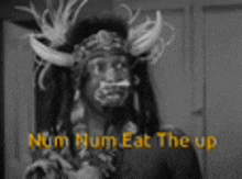 a black and white photo of a man in a native american costume with horns on his head .