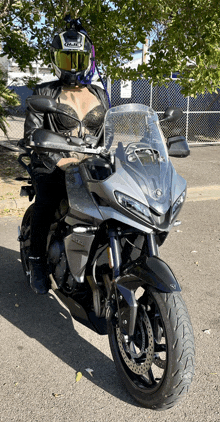 a woman wearing a helmet stands next to a yamaha motorcycle