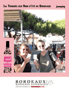 two women standing next to each other in front of a sign that says la tournee des vins d ' ete de bordeaux