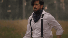 a man in a white shirt with suspenders and a bandana is edited by jason king