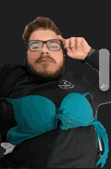 a man with glasses and a beard is wearing a blue bra