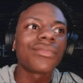 a young man wearing headphones is making a funny face and smiling .
