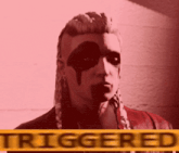 a woman with black paint on her face is standing in front of a sign that says triggered