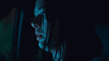 a woman 's face is visible in a dark room