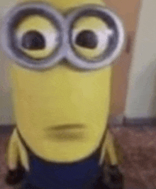 a close up of a minion wearing goggles making a funny face .