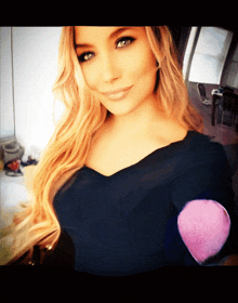 a woman taking a selfie with a pink sponge on her elbow