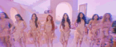 a group of women are standing next to each other in pink dresses in a room .
