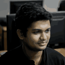 a man in a black shirt is sitting in front of a computer