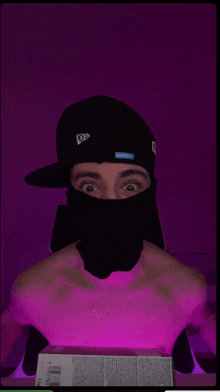 a man wearing a balaclava and a hat with a purple background