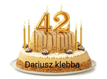 a birthday cake with gold candles and the name dariusz klebba on it