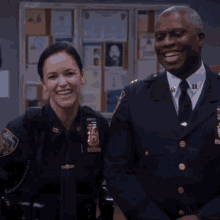 a man and a woman are posing for a picture and the woman has a patch on her uniform that says nypd on it