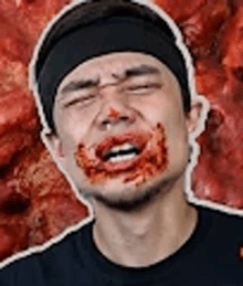 a man with blood on his face is making a funny face .