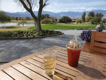 a plastic cup with a drink in it sits on a wooden table