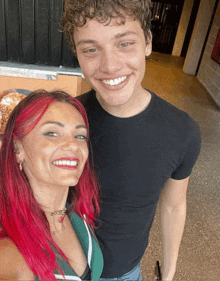 a woman with red hair smiles next to a man