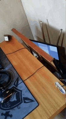 a computer is sitting on top of a wooden desk next to a mouse pad .