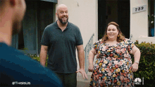 a man and a woman are standing in front of a house with a sign that says ' 738 ' on it