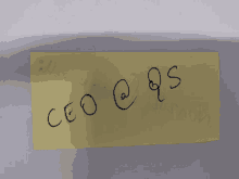 a yellow piece of paper with the letters ceo @ qs written on it