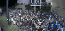 a large crowd of people are gathered in front of a building with a sign that says espn on it