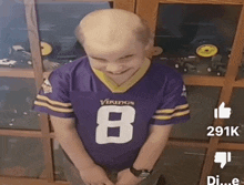 a young boy wearing a vikings jersey with the number 8