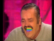 a man with a mustache is laughing with a rainbow colored tongue sticking out .