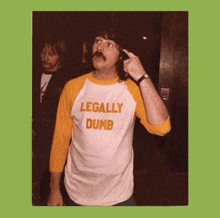 a man wearing a shirt that says legally dumb on it