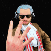 a man wearing headphones and sunglasses is making a peace sign with his hand