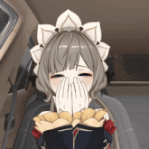 a girl covering her face with her hands while holding a book