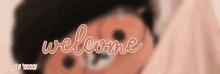 a blurred image of a teddy bear with the word welcome written on it