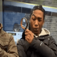 a man is holding a magnifying glass and looking through it .