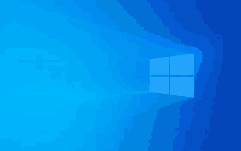 the windows logo is glowing in the dark on a bright blue background .