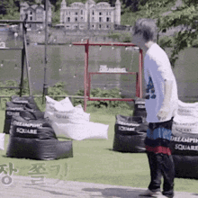 a man in a white shirt is standing in front of a bunch of bean bag chairs that say dreaming square